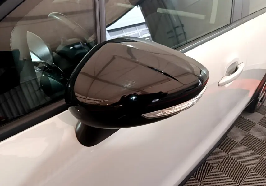 Rétroviseur noir brillant côté gauche sur porte blanche d'une Citroën C3 Aircross 2019 vue de près.