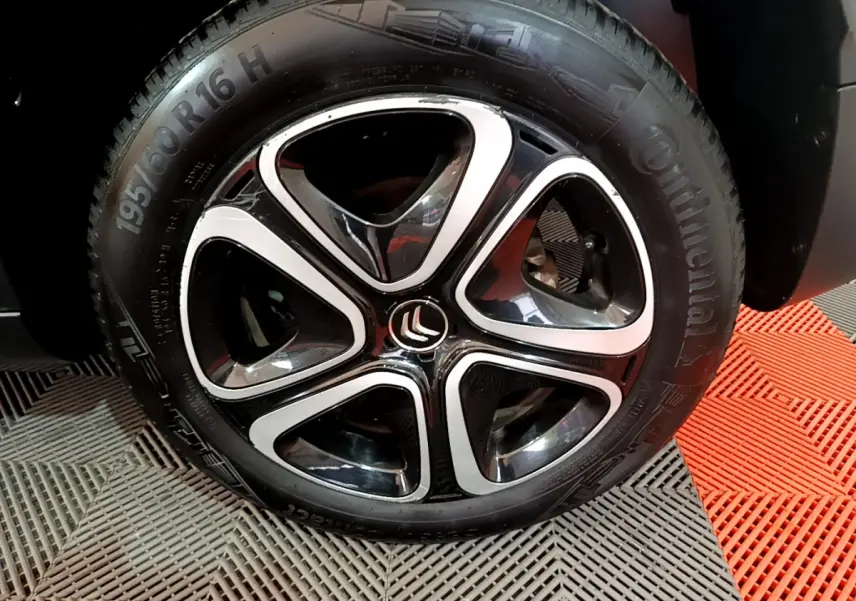 Gros plan sur la jante noire et argentée d'une Citroën C3 Aircross blanche, pneu Continental visible.