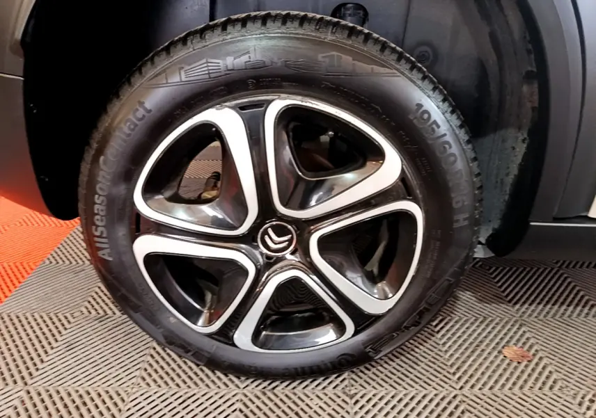 Gros plan sur la roue avant gauche du Citroën C3 Aircross blanc, mettant en valeur la jante alliage noire et argentée.