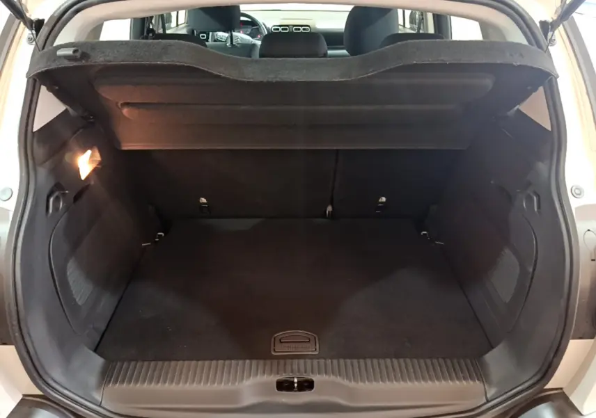 Coffre ouvert vu de l'arrière d'un Citroën C3 Aircross blanc, montrant un espace de chargement propre et spacieux.