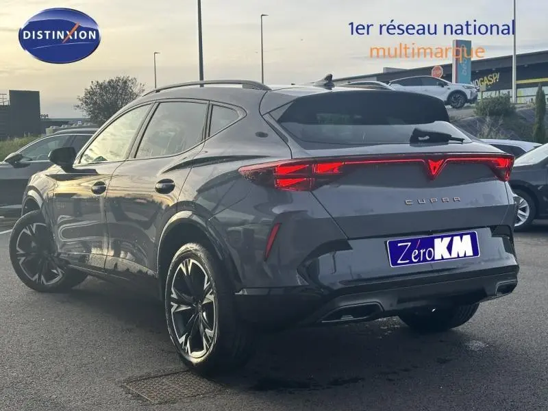 Vue 3/4 arrière droite d'un CUPRA Formentor gris 2025 avec feux arrière LED et jantes noires distinctives.