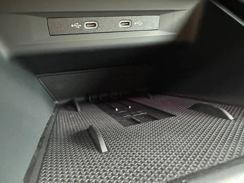 Gros plan sur la console centrale du CUPRA Formentor 2025, montrant les ports USB-C intégrés au dessus d'un tapis antidérapant noir.