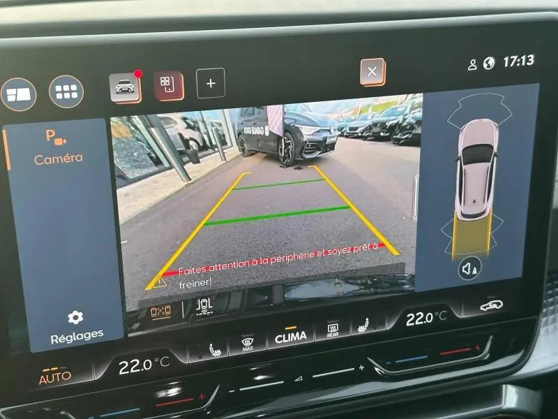 Vue écran caméra de recul du CUPRA Formentor gris 2025, avec lignes de guidage et alertes de proximité visibles.