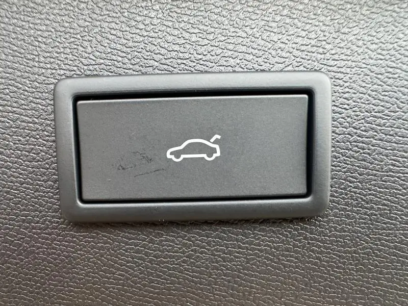 Bouton intérieur noir avec pictogramme blanc d'ouverture de coffre, sur tableau de bord d'une CUPRA Formentor gris 2025.