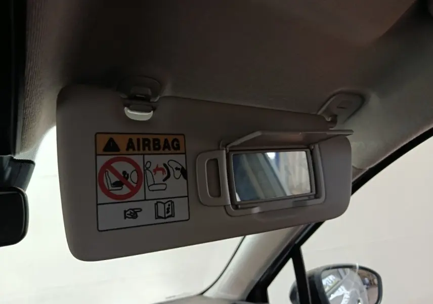 Détail du pare-soleil côté conducteur avec miroir et avertissement airbag dans l’habitacle gris clair d’une Renault Clio 2023.