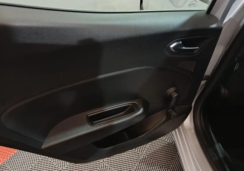 Vue intérieure de la porte avant droite d’une Renault Clio gris clair avec poignée et lève-vitre manuel noir.