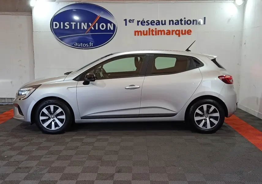 Profil droit d'une Renault Clio Equilibre TCe 90 gris clair 2023, avec jantes bi-ton et feux arrière LED visibles.
