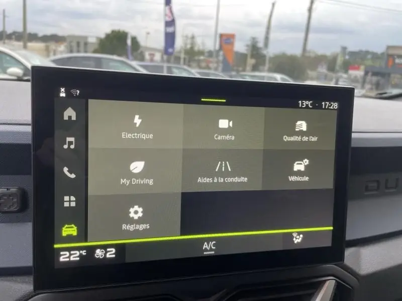 Écran tactile central du Dacia Duster 1.6 Hybrid 140 cv 2025, affichant les options de conduite et réglages, intérieur gris.