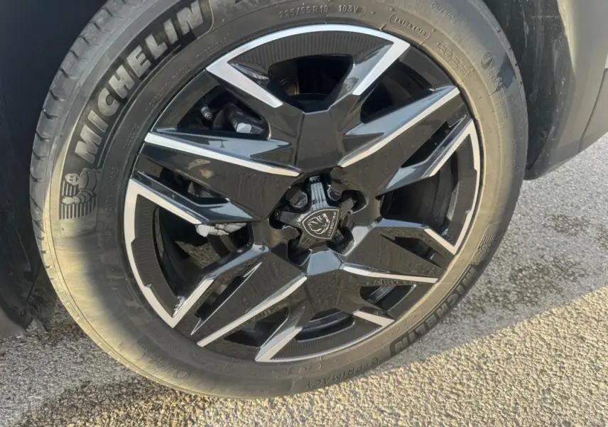 Gros plan sur la jante alliage noire et argentée de 19 pouces du Peugeot 3008 Hybrid 145 e-DCS6 Allure gris.