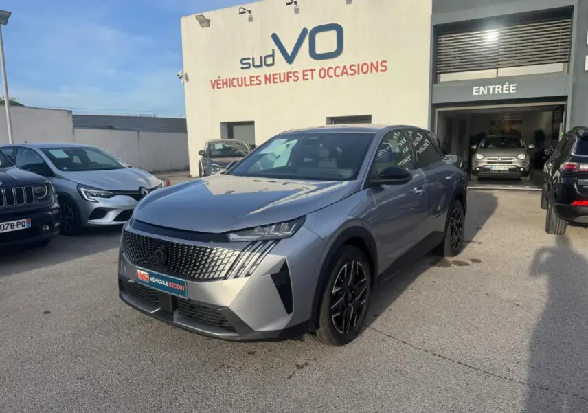 Peugeot 3008 Hybrid gris en 3/4 avant droit, avec calandre distinctive et jantes alliage noires de 19 pouces.
