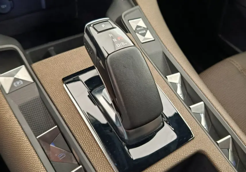 Gros plan sur la commande de boîte automatique noire dans l'intérieur marron du DS7 Crossback E-TENSE 225 BUSINESS.
