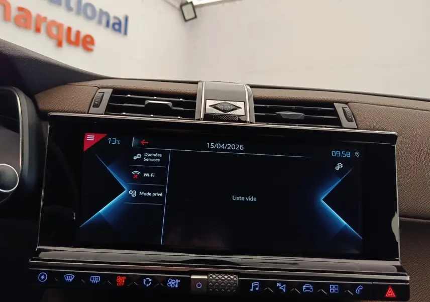 Vue rapprochée de l’écran tactile central noir du tableau de bord marron du DS7 Crossback E-TENSE 225 BUSINESS gris clair.