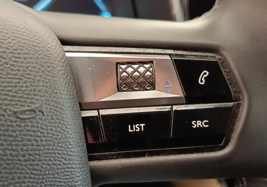 Gros plan sur les commandes multifonctions du volant cuir noir d'un DS7 Crossback E-TENSE 225 BUSINESS.