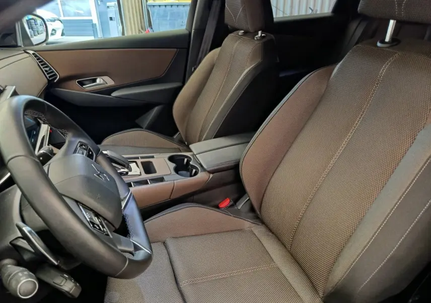 Vue intérieure côté conducteur du DS7 Crossback E-TENSE 225 Business 2022, sièges tissu marron et volant cuir multifonctions.