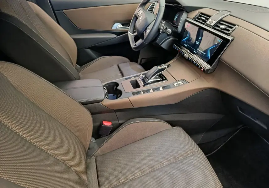 Vue intérieure côté conducteur du DS7 Crossback E-TENSE 225 Business, montrant sièges marron et console centrale avec écran tactile.