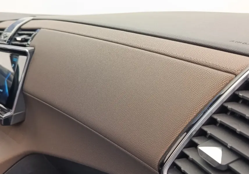Détail de la planche de bord en cuir marron du DS7 Crossback E-TENSE 225 BUSINESS, avec sortie d’air chromée.