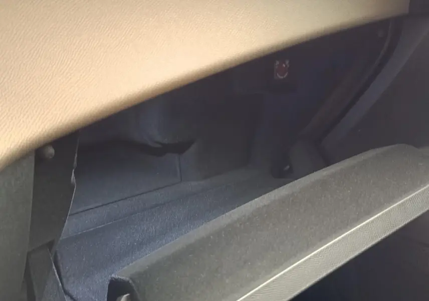 Vue intérieure du coffre à gants ouvert du DS7 Crossback E-TENSE 225 BUSINESS avec revêtement noir et partie supérieure beige.