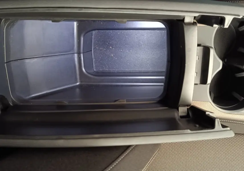 Vue plongeante sur l'accoudoir central ouvert du DS7 Crossback E-TENSE 225 Business, intérieur beige et rangement vide.