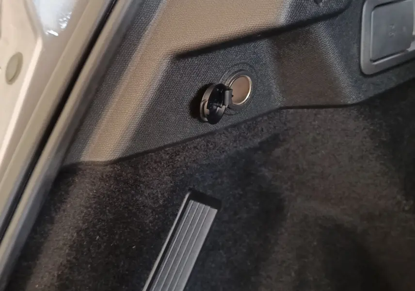 Détail de la prise de charge latérale arrière dans le coffre du DS7 Crossback E-TENSE gris clair, vue rapprochée.