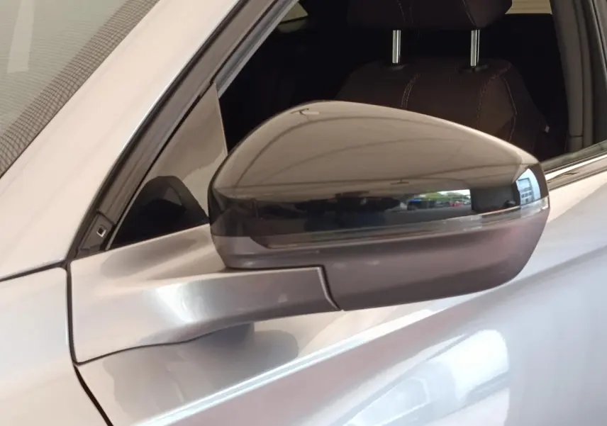 Rétroviseur droit gris clair du DS7 Crossback E-TENSE 225 BUSINESS, vue rapprochée sur la portière et l'intérieur cuir.