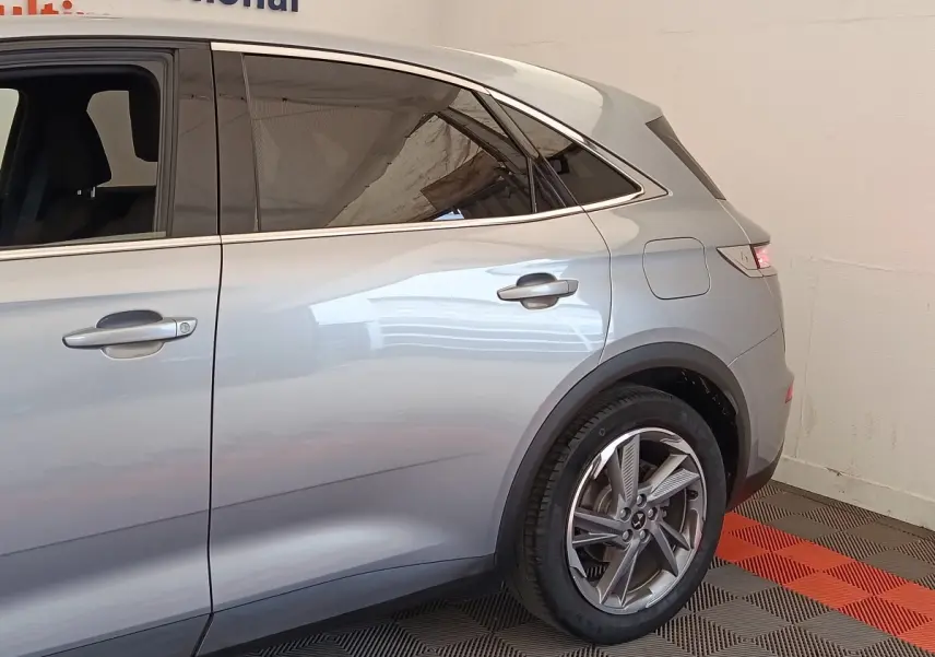 Vue latérale droite du DS7 Crossback E-TENSE 225 Business gris clair, mettant en valeur les jantes alliage et les vitres teintées.