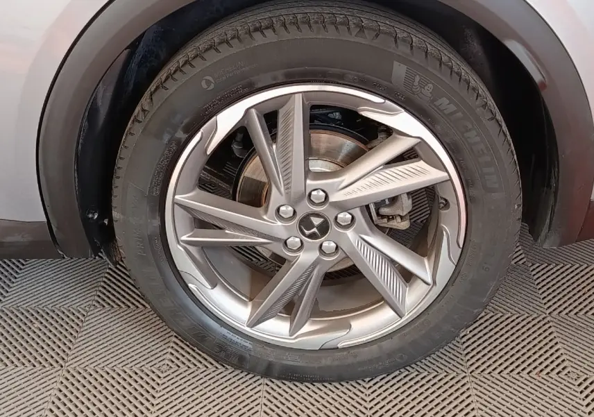 Gros plan sur la roue avant droite gris clair du DS7 Crossback E-TENSE 225 avec jante alliage au design moderne.