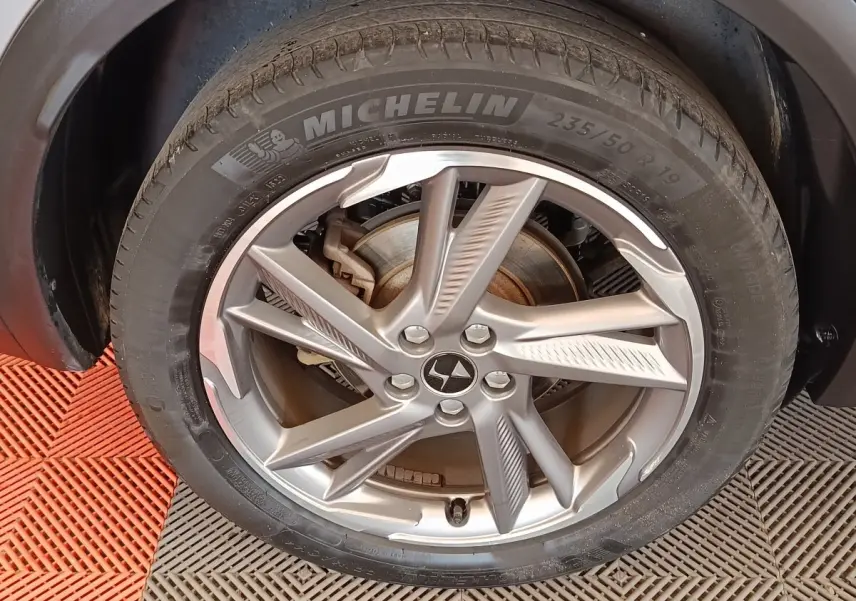 Gros plan sur la roue avant droite gris clair du DS7 Crossback E-TENSE 225 BUSINESS avec jante alliage et pneu Michelin.