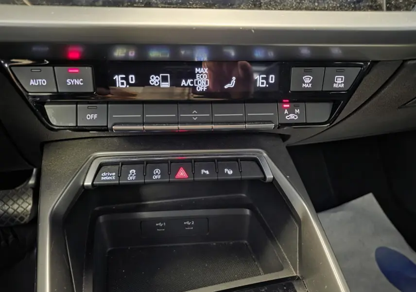 Gros plan sur la console centrale de l’Audi A3 Sportback 2023 avec commandes climatisation et boutons multifonctions.