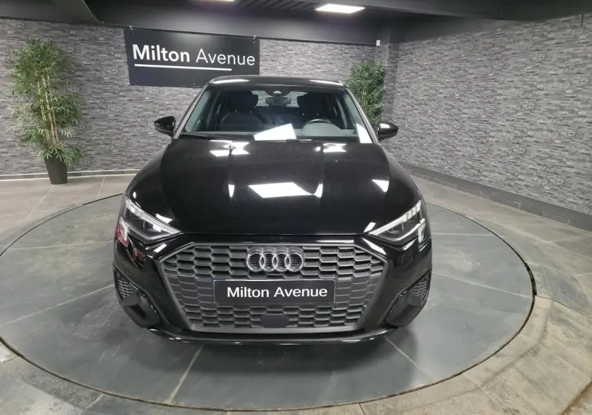 Vue avant d'une Audi A3 Sportback noire 2023 avec calandre hexagonale et phares LED dynamiques.