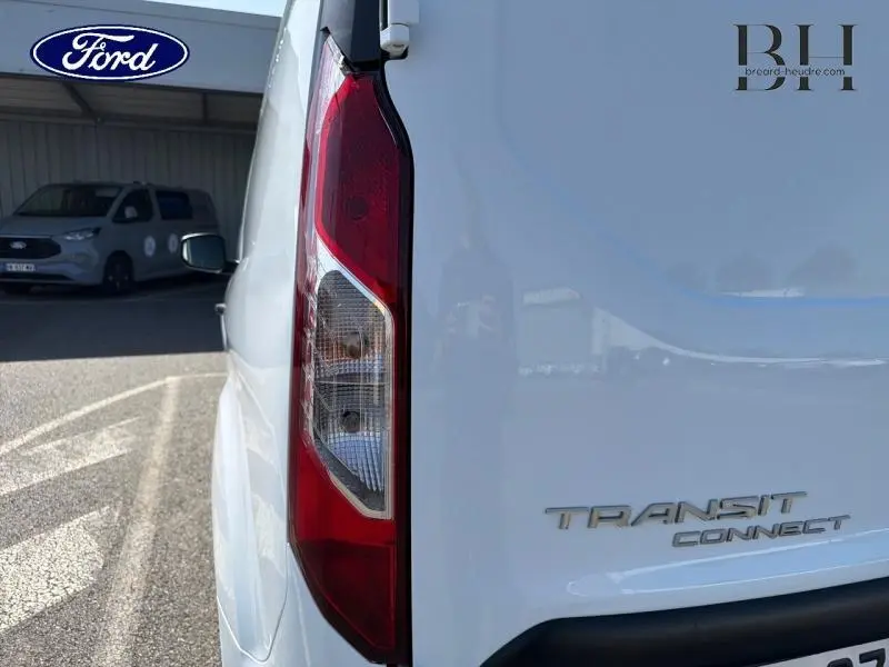 Gros plan sur l’arrière droit blanc glacier du Ford Transit Connect avec feu arrière et logo visible.
