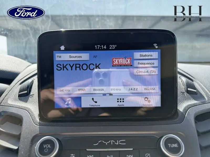 Écran tactile SYNC 3 du Ford Transit Connect L1 blanc glacier, affichant la radio Skyrock en intérieur véhicule.