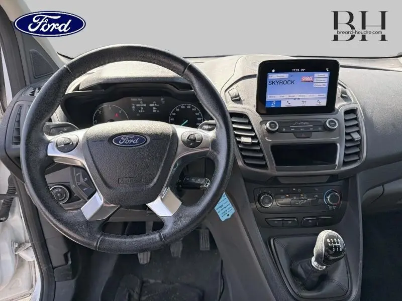 Vue intérieure du tableau de bord du Ford Transit Connect blanc glacier, avec volant multifonction et écran central SYNC 3.