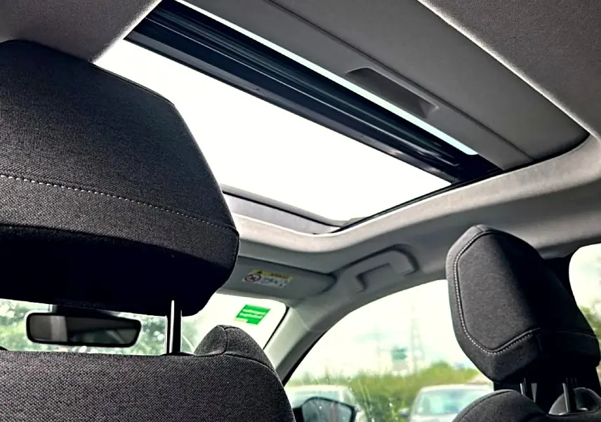 Vue intérieure du toit ouvrant panoramique et des appuie-têtes avant en tissu gris foncé du Citroën C4 2024.