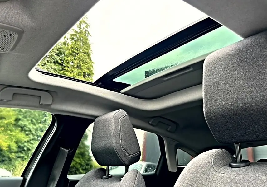 Vue intérieure du toit ouvrant panoramique et des appuie-têtes avant en tissu gris du Citroën C4 2024.