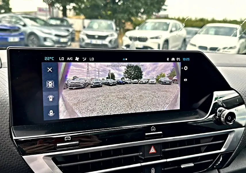 Écran tactile intérieur de Citroën C4 gris 2024 montrant la caméra de recul avec vue arrière sur parking.