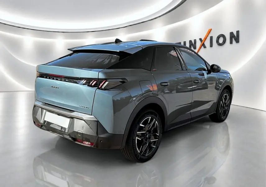 Vue 3/4 arrière droite d’un Peugeot 3008 bleu 2025 avec jantes alu et toit noir dans un showroom moderne.