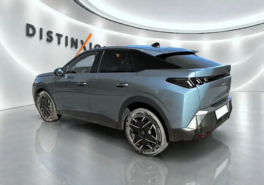 Peugeot 3008 bleu en 3/4 arrière droit, avec jantes alu noires et toit noir contrasté dans un showroom lumineux.