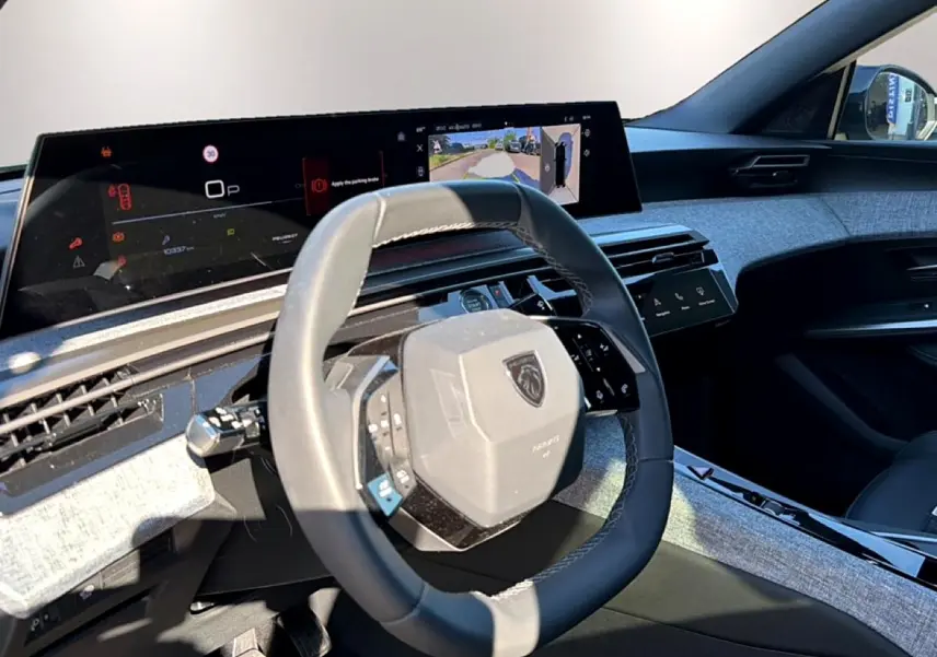 Vue intérieure côté conducteur du Peugeot 3008 1.2 hybrid 145 allure 2025, volant cuir et tableau de bord numérique.