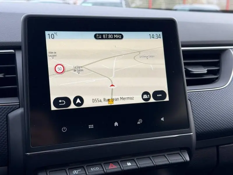 Écran tactile central du Renault Arkana 2025 affichant la navigation, entouré de la console noire et des aérateurs.