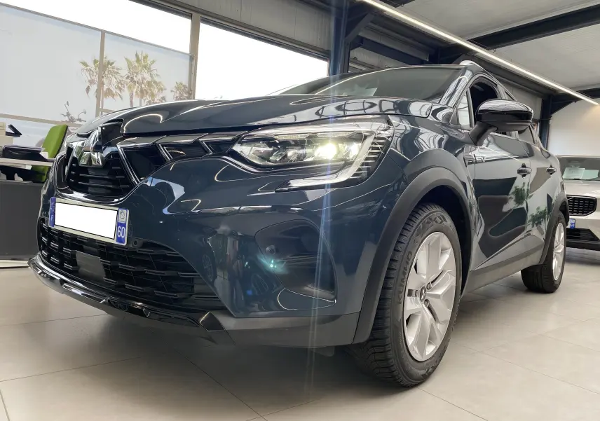 Vue 3/4 avant droit du Mitsubishi ASX 2023 Steel Gray métallisé avec phares allumés en showroom.