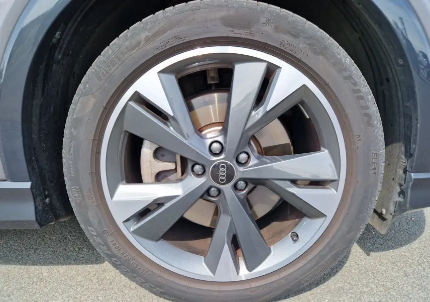 Gros plan sur la roue avant droite de l'Audi Q4 E-TRON Sportback gris thyphon avec jante en alliage à design moderne.