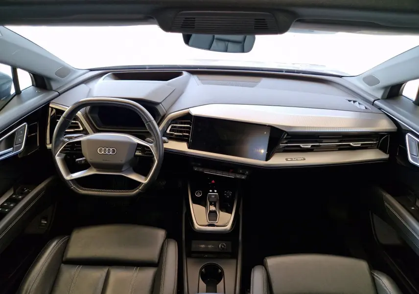 Intérieur de l'Audi Q4 E-TRON SPORTBACK 50 quattro 2022, vue frontale du tableau de bord et volant cuir noir.