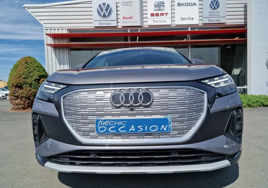 Vue frontale d'un Audi Q4 E-TRON SPORTBACK gris thyphon avec calandre fermée et logo Audi lumineux.