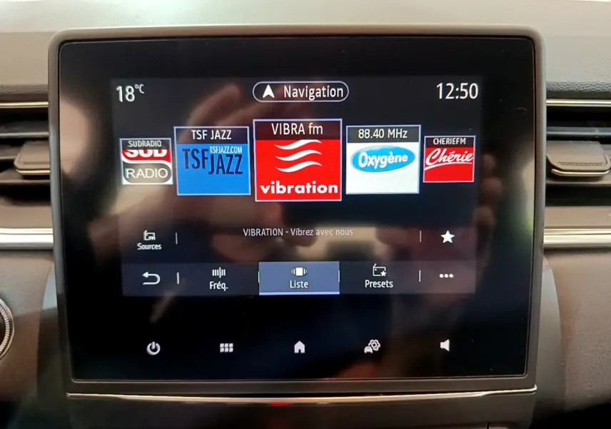 Écran tactile central du tableau de bord du Renault Captur Business Blue dCi 95, affichant les radios FM en mode navigation.