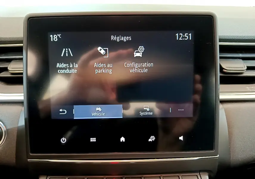 Écran tactile central du tableau de bord du Renault Captur Business noir, affichant les réglages d’aide à la conduite et parking.