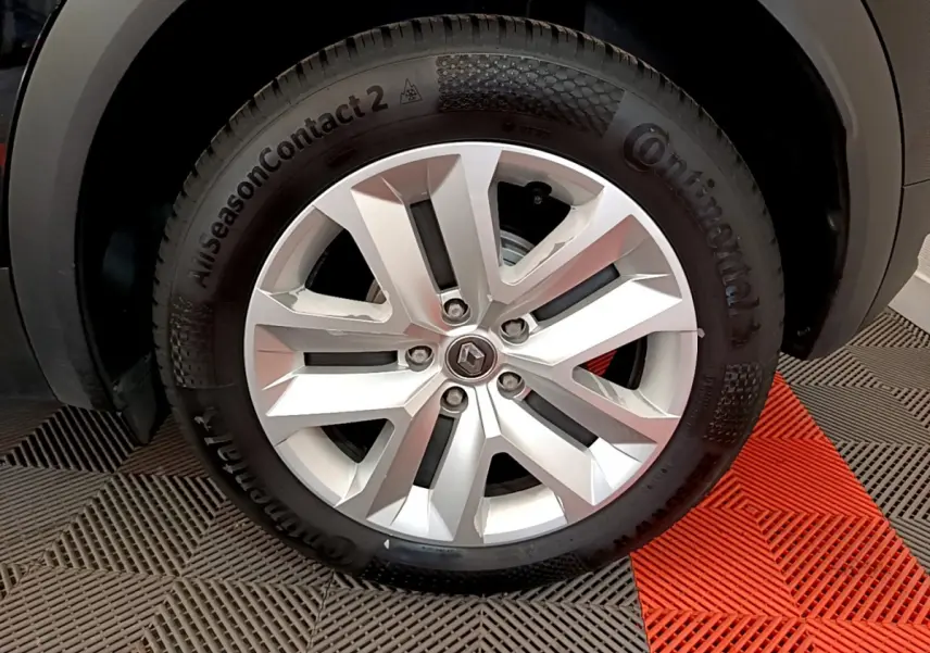 Gros plan sur la roue avant droite du Renault Captur Business noir, mettant en valeur la jante argentée et le pneu Continental.