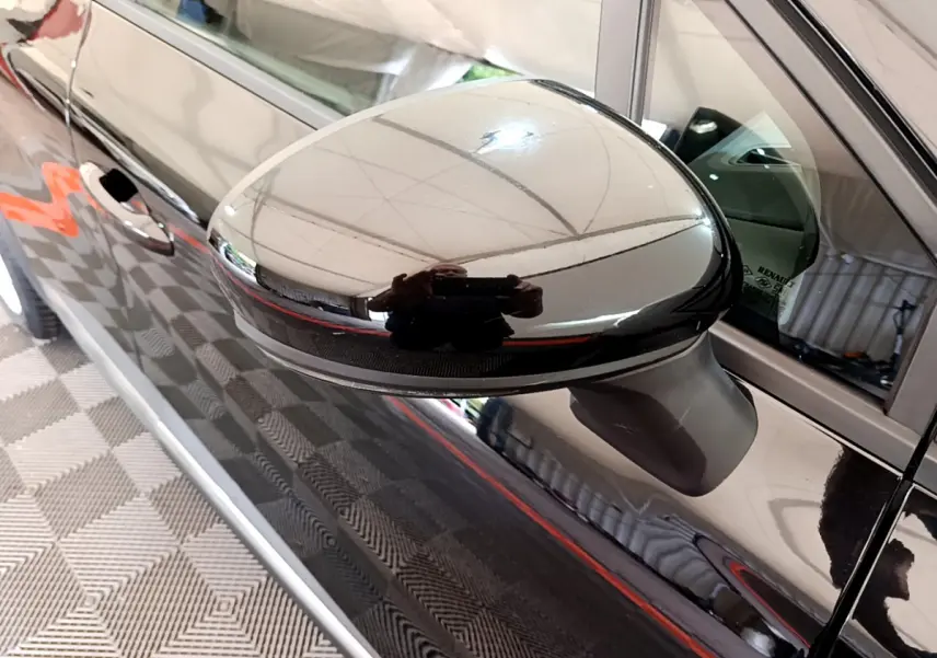Rétroviseur côté gauche noir brillant du Renault Captur Business 2020, reflétant l'intérieur et l'environnement proche.