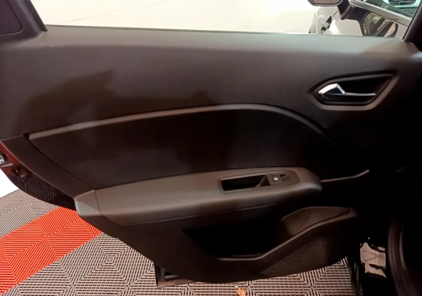 Gros plan sur la porte intérieure côté droit noire du Renault Captur 2020 avec commandes de vitre visibles