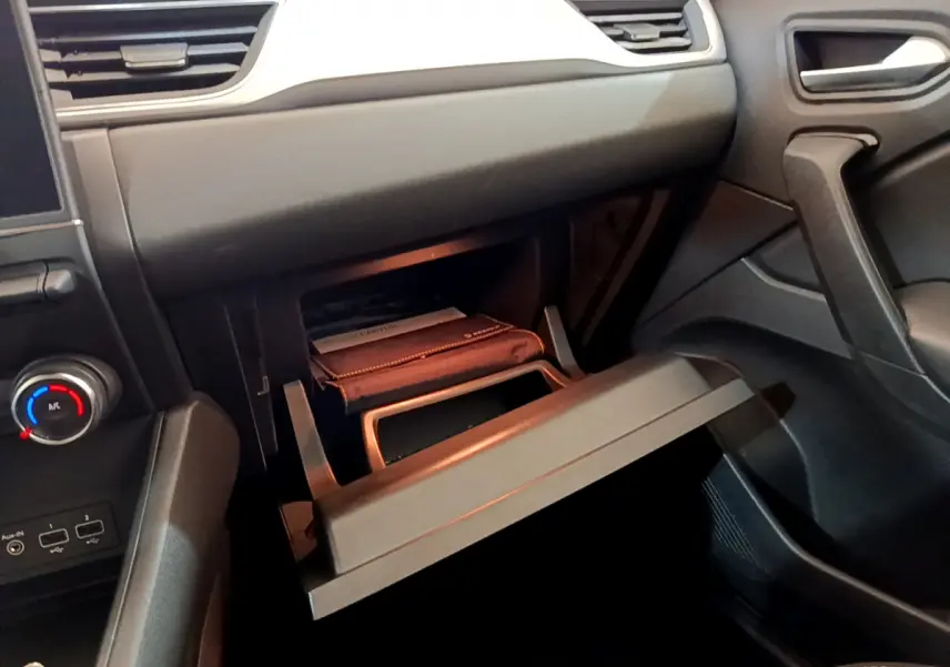 Intérieur du Renault Captur Business 2020, vue côté passager sur la boîte à gants ouverte avec manuel visible.