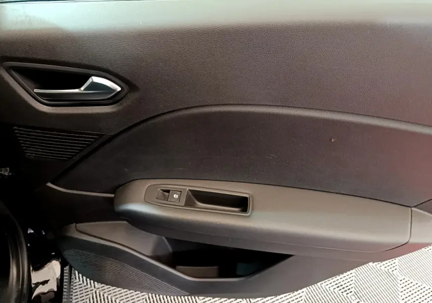 Gros plan sur la porte côté gauche noire du Renault Captur Business 2020, avec poignée argentée et commande de vitre.